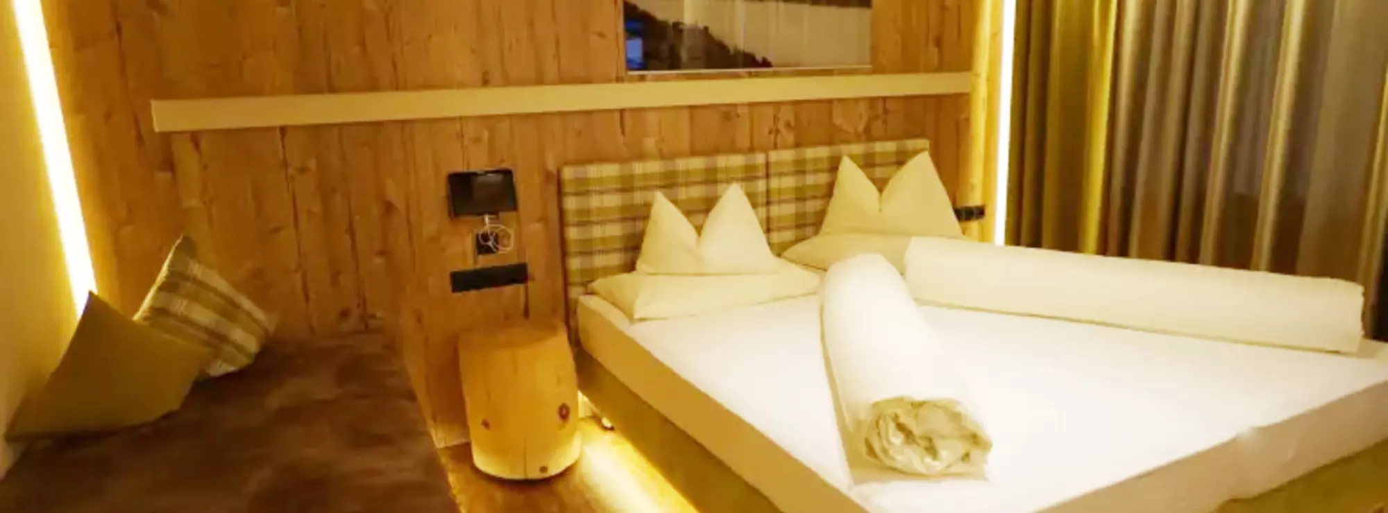 Schlafzimmer mit Wänden und Decke aus Holz und Zusatzbett