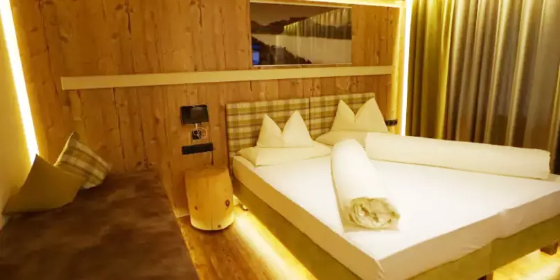 Schlafzimmer mit Wänden und Decke aus Holz und Zusatzbett