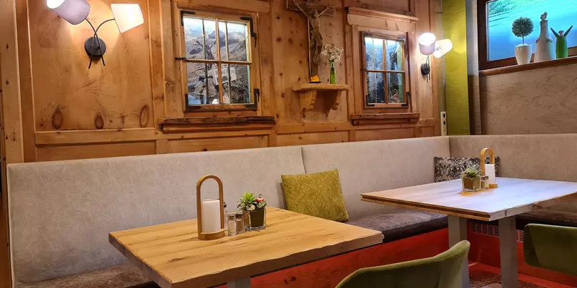 Speisesaal mit Holzvertäfelung, modernen Sesseln und gemütlicher Sitzgarnitur