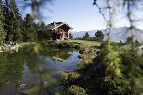 Kleines Haus an einem See in den Bergen im Sommer